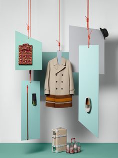 a coat hanging from hooks in front of an open door with other items on the floor