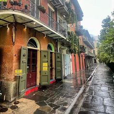 an old brick building with green doors and balconies