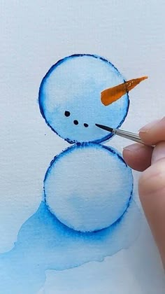 someone is painting a snowman with watercolors