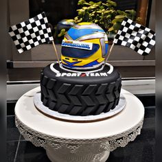 a motorcycle helmet and checkered flags on top of a cake