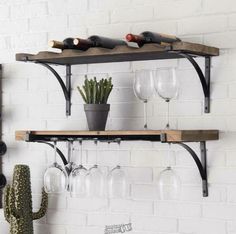 two wooden shelves with wine glasses and a cacti on one shelf next to the other