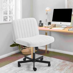 an office chair sitting in front of a computer on top of a desk next to a window