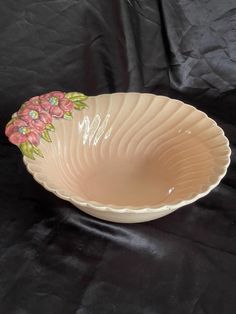 a pink flowered bowl sitting on top of a black table