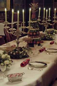 a table set with candles and flowers on it for a formal dinner or function in the dining room