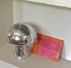 a disco ball sitting on top of a counter next to a sign that says disco therapy