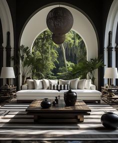 a living room filled with lots of furniture next to an arch covered in palm trees