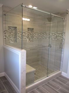 a walk in shower sitting next to a tiled wall