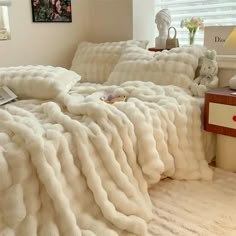 a bed with white blankets and pillows on top of it