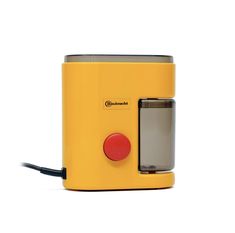 a yellow toaster sitting on top of a white table next to a red button