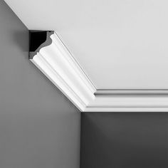 a black and white photo of a light fixture on the ceiling in a room with gray walls