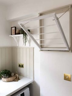 a shelf with some plants on top of it and a basket in the corner next to it