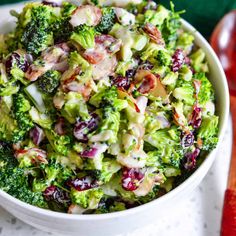 a white bowl filled with broccoli salad on top of a table