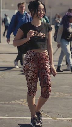 a woman riding a skateboard on top of a parking lot next to other people