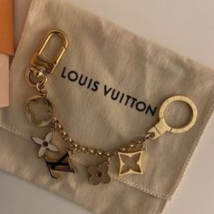 a louis vuitton keychain with charms on it