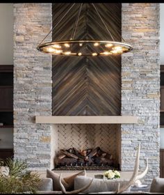 a living room filled with furniture and a fire place in front of a stone wall