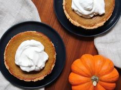 two plates with pumpkin pies and whipped cream