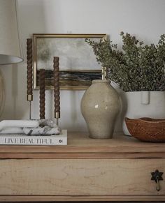 a white vase sitting on top of a wooden dresser