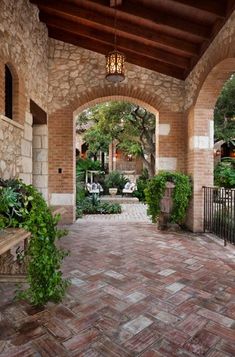 an arched walkway leads to a courtyard with potted plants