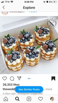 a box filled with lots of cupcakes covered in blueberries