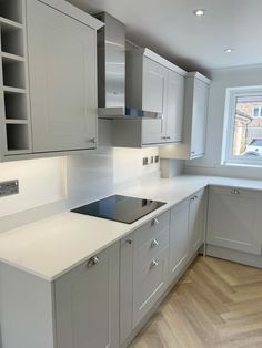 a kitchen with white counter tops and gray cabinets