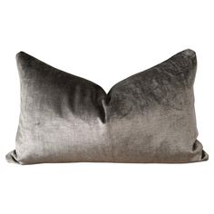 a gray and black pillow sitting on top of a white wall