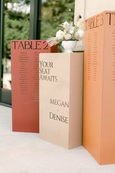 the table is set up with two tall books and a vase filled with white flowers