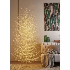 a white christmas tree in a living room next to a couch and painting on the wall