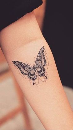 a small butterfly tattoo on the left forearm and right arm, it is black and white