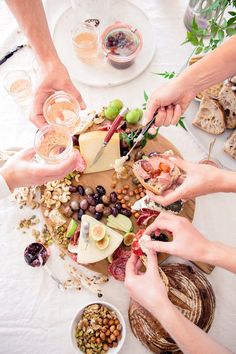 several people are serving themselves food at a table