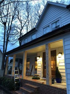 the porch is lit up at night with lights on and steps leading to the front door