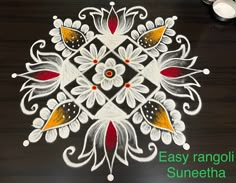 an easy rangolim design for diwaling with white and red flowers on black background