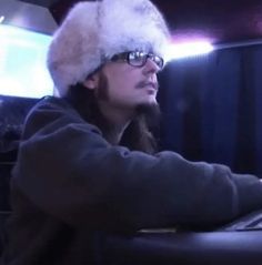 a man wearing a furry hat using a laptop