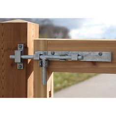 a close up of a wooden door with a metal latch on the front and side