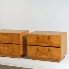 two wooden boxes sitting on top of a white table next to each other with one drawer open