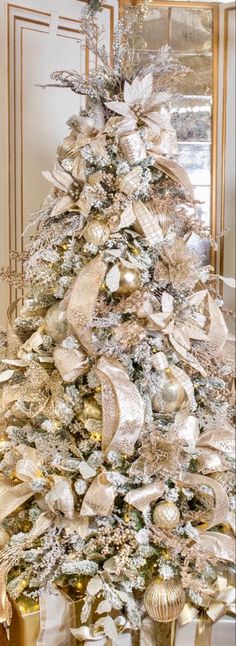 a white christmas tree with gold and silver decorations