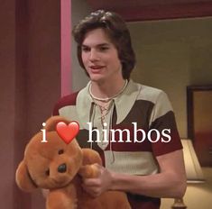 a woman holding a brown teddy bear with the words i love himbos on it