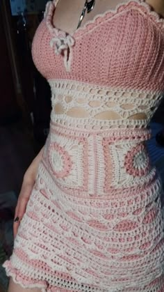 a woman is wearing a pink dress with crocheted details