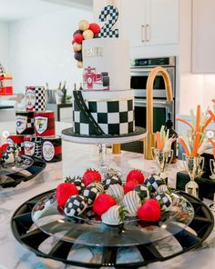 a cake on a black and white plate sitting on a counter next to other desserts