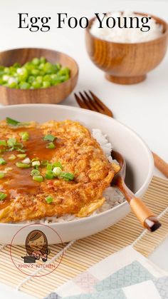 a bowl filled with rice covered in sauce and green onions