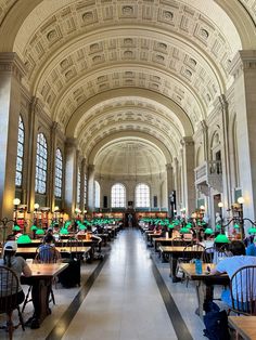 the inside of a large building with tables and chairs on both sides of the room