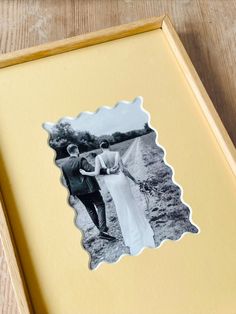 an old photo in a wooden frame on a table