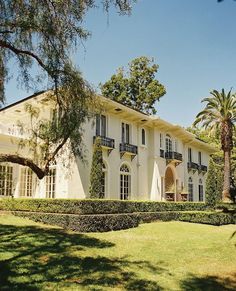 a large white house surrounded by lush green trees