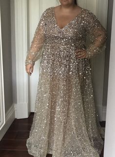 a woman standing in front of a doorway wearing a dress with sequins on it