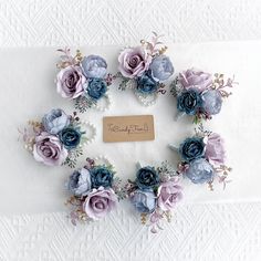 a bunch of blue and purple flowers arranged in a circle on top of a white table cloth