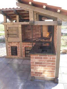 an outdoor oven built into the side of a brick building with a grill on top