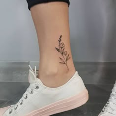 a woman's foot with a flower tattoo on the side of her shoe,