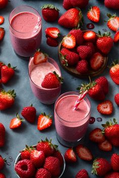 two glasses filled with smoothie next to strawberries