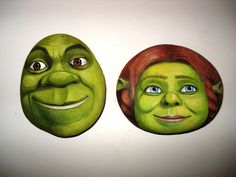 there are two green masks with faces painted on them, one has red hair and the other has blue eyes