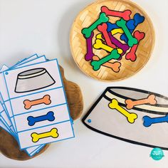 a wooden bowl filled with dog bones and bones on top of a table next to cut outs