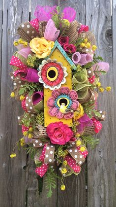 a birdhouse decorated with flowers and ribbons